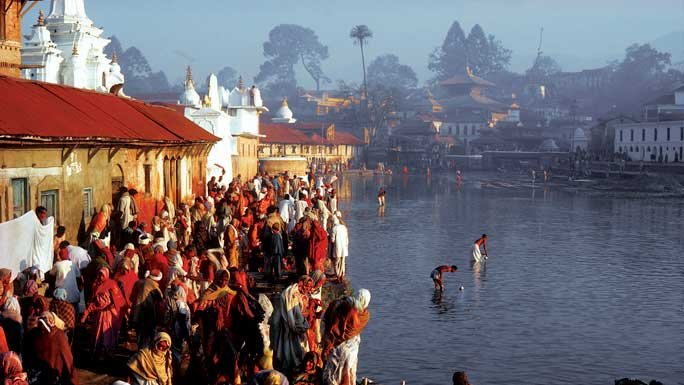 Devotees bathing by the Bagmati River on the banks of the Pashupatinath Temple in Kathmandu, Nepal. 