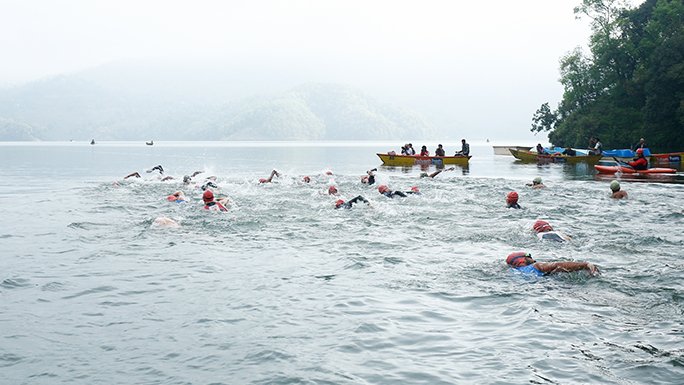 Triathletes swimming in Begnas Lake during Himalayan Rush Triathlon, Pokhara, Nepal. 